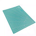 Teal cutting mat with grid lines on a white background