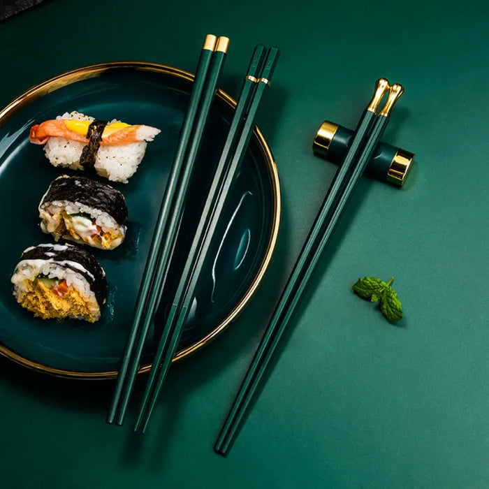 Sushi on a plate with green chopsticks on a green background
