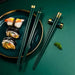 Sushi on a plate with green chopsticks on a green background