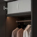 Closet with hanging clothes and a partially open door
