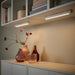 Two dimmable LED light bars mounted under kitchen cabinets, providing warm ambient lighting for decorative vases.