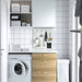 IKEA SKÅDIS 7-piece accessories set in white mounted on pegboard in tiled laundry room; organizing notes, clips, and small items beside folded towels and glass jars – ideal for utility space storage and wall organization - 80586417