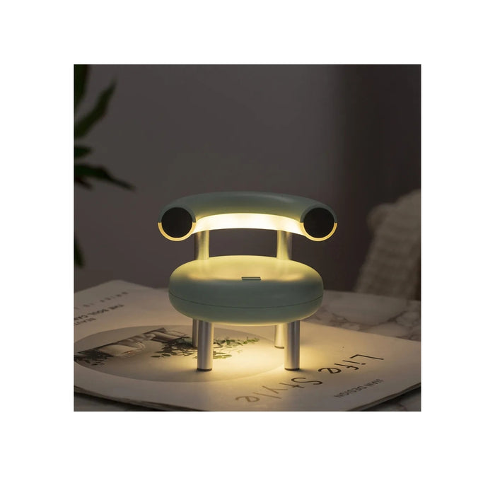 Small lamp shaped like a chair on a surface with a dark background