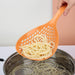 slotted spoon scooping fried snacks from hot oil
