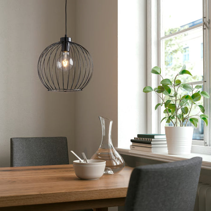 Dining room with a wooden table, black pendant light, gray chairs, and a plant by the window.