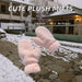 cute plush pink gloves floating in snowy town background
