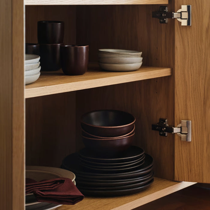 Wooden cabinet with shelves containing ceramic bowls and plates.
