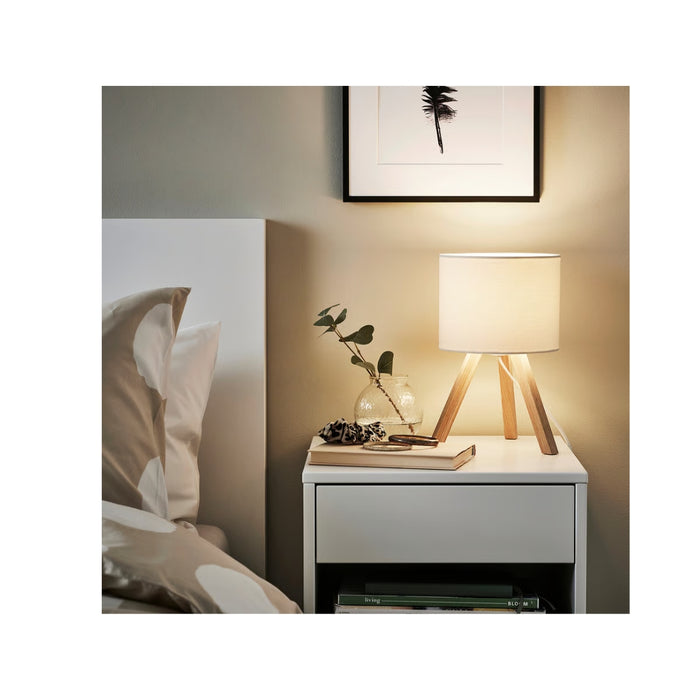 Nighstand with lamp and decorative items in a bedroom setting