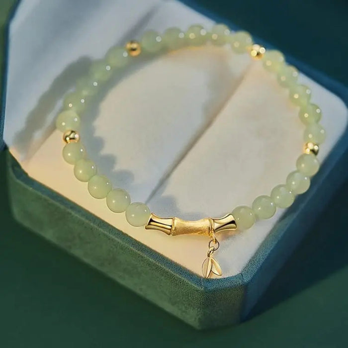 Green beaded bracelet with gold accents in a green box