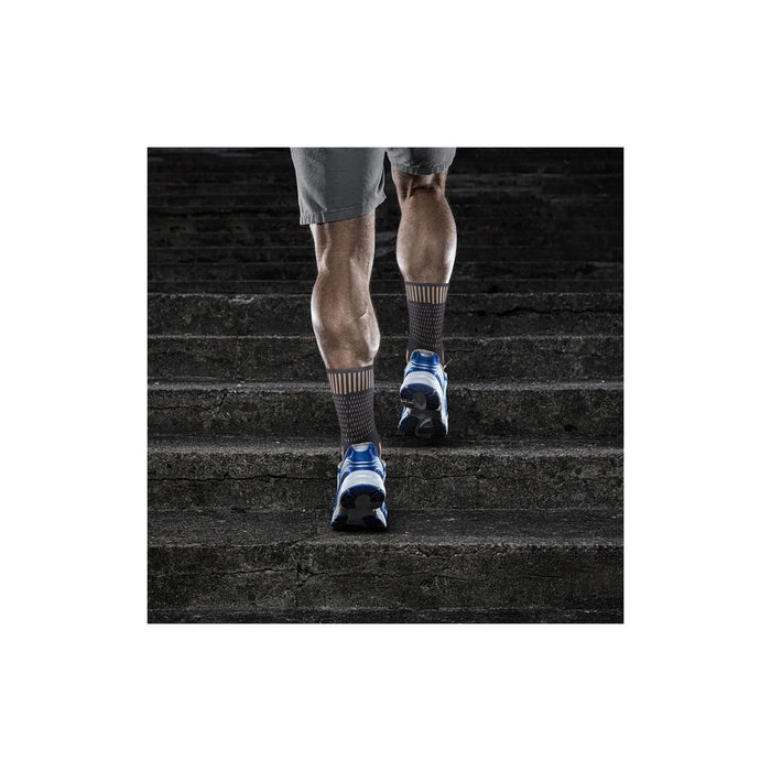 Person walking up stairs wearing gray socks and blue athletic shoes.
