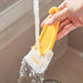 Yellow kitchen scraper being rinsed under running water in a sink – 1598449174494 14075321