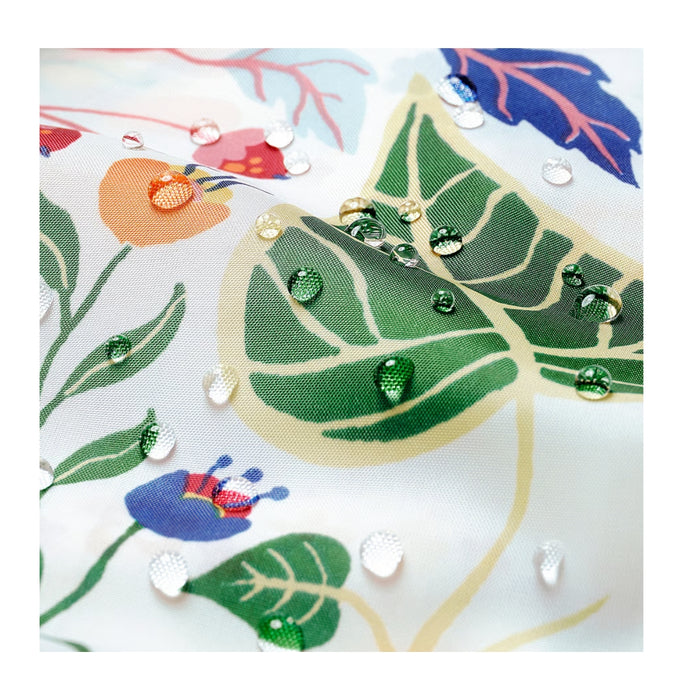 Close-up of a fabric with green leaves and colorful flowers, featuring beads and buttons.