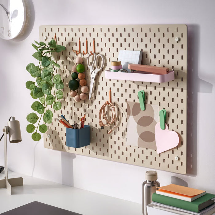 Pegboard with various office supplies on a white wall