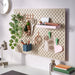 Pegboard with various office supplies on a white wall