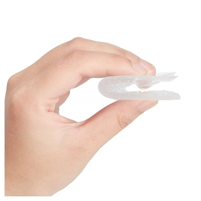 Hand holding a small white silicone product against a white background