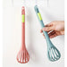 Red and teal whisk-tong hybrids with sliding mechanism, shown hanging and handheld for versatile kitchen use