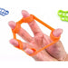 Hand using an orange finger exerciser with a white background