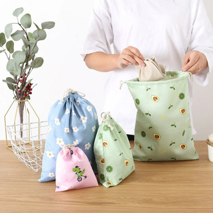 Set of colorful drawstring bags on a wooden table, including blue floral and green fruit prints – 1598445710448 14078092