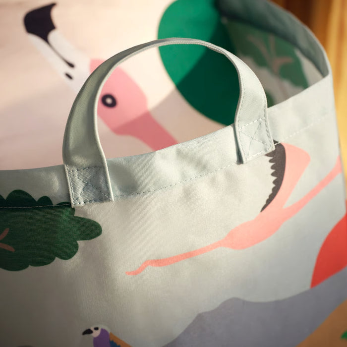 Children's apron with colorful bird design on a wooden surface