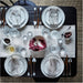 Elegant table setting with white plates, silverware, and a centerpiece on a textured surface.