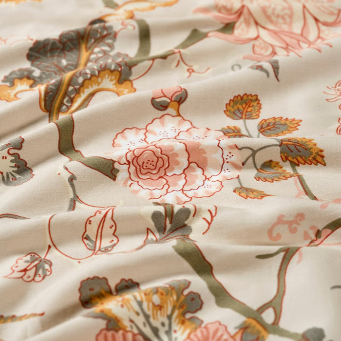 Close-up of floral fabric with pink and green flowers on a beige background