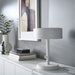 White table lamp on a white surface with a neutral background