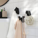 IKEA FRÖSÅDD black animal-shaped hooks mounted in bathroom, holding towels and bath accessories