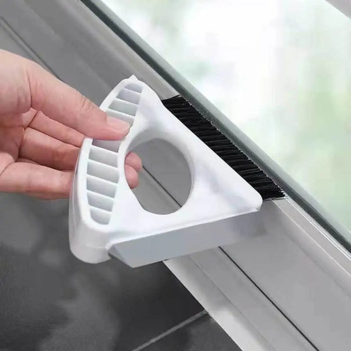 Window cleaning tool with a brush being used to clean a window