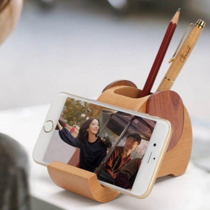 Wooden phone stand holding a smartphone with a blurred background