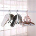 Shoe rack holding various pairs of shoes against a neutral background