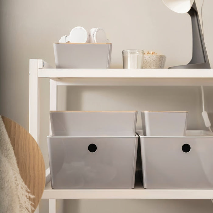 White shelving unit with neatly organized storage boxes, featuring IKEA KUGGIS light grey storage solutions, a lamp, headphones, and decorative elements—ideal for home organization and modern interior decor.- 20599149