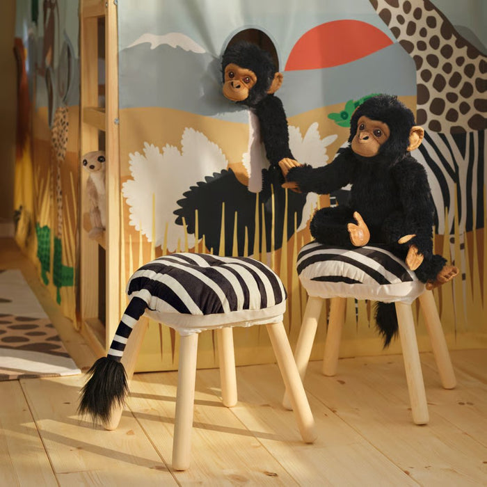  Meerkat plush toys interacting with zebra-patterned stool in creative playroom setup with art supplies