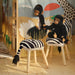  Meerkat plush toys interacting with zebra-patterned stool in creative playroom setup with art supplies