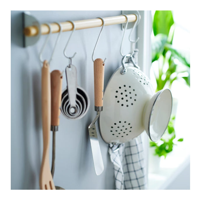 Set of kitchen utensils hanging on a rack with a blurred background