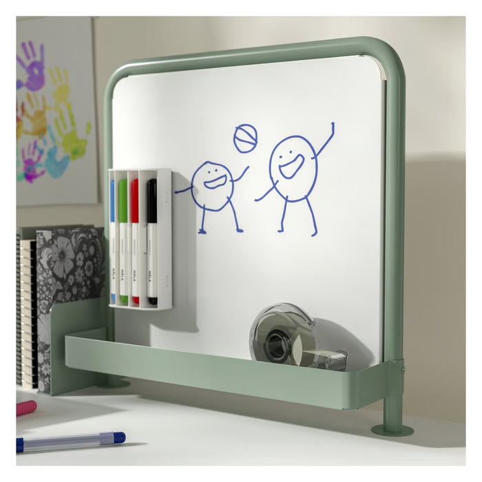 Whiteboard with green frame and drawing of people playing basketball, with stationery items below.