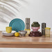 SPJUTLILJA bowls arranged with plates and cups in colorful kitchenware display, stacked with striped containers and lemon accent