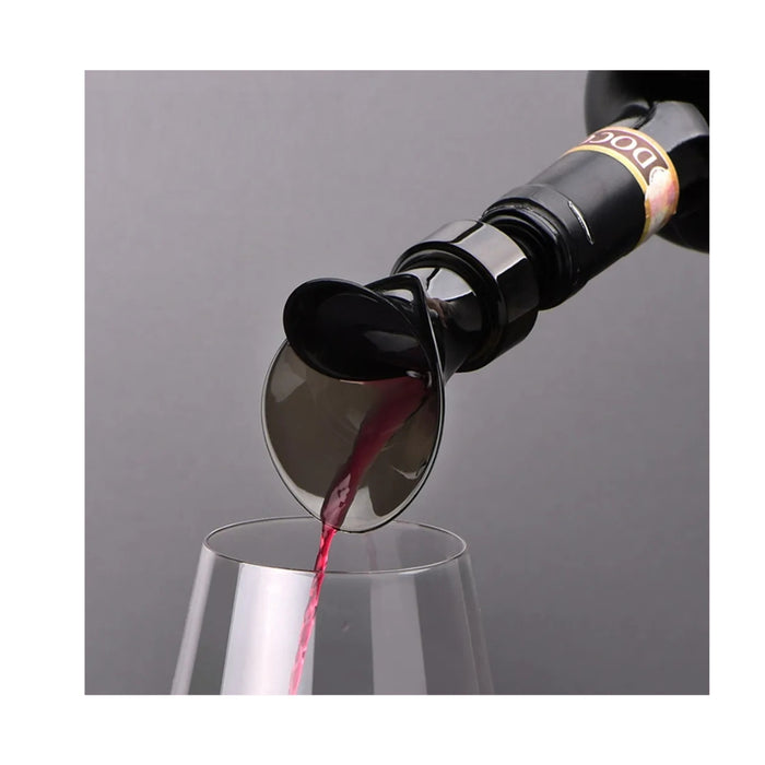 Wine bottle being uncorked with red wine pouring into a glass on a gray background