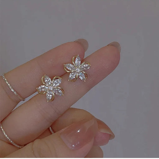 Digital Shoppy High-grade Ear Studs, hand holding flower-shaped earrings with sparkling zircon petals and gold outline