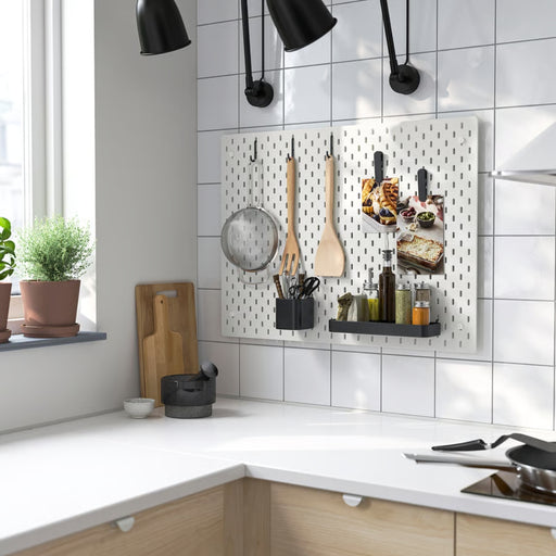 Black SKÅDIS pegboard accessories including hooks, shelf, and containers