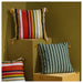 Colorful striped pillows on geometric wooden blocks against a brown background