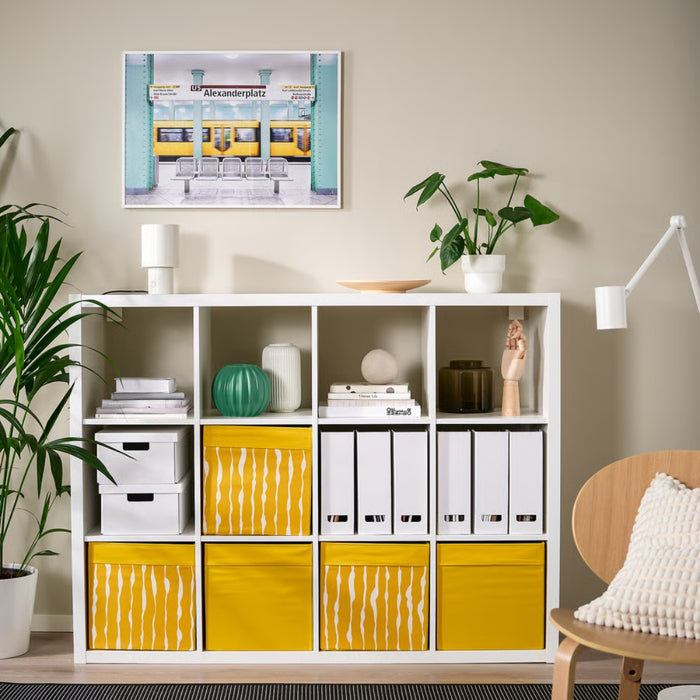 IKEA DRÖNA Box in dark yellow with white wavy-line design, neatly placed on a white shelf, storing folded clothes and accessories—ideal for stylish home organization.-00603331