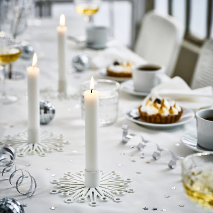 Elegant celebration setup featuring FRÖJDA holders with white candles, desserts, and sparkling drinks in a winter-themed arrangement
