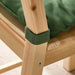 Close-up of a wooden chair with green fabric on a light background