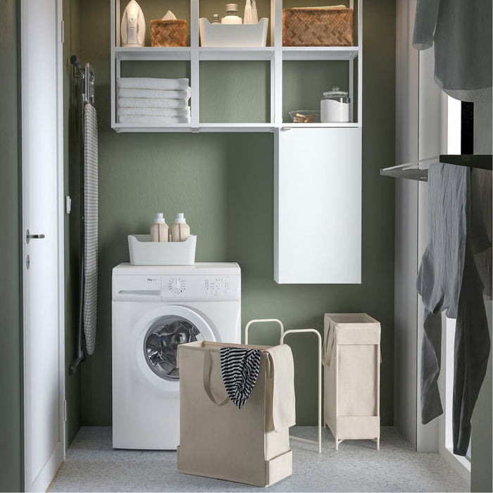Laundry room with washing machine, dryer, and shelves on a green wall.
