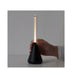 Hand holding IKEA BJÖRKSPIREA black LED decoration light showing slim tube design and dimmer ring