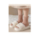 Pair of fluffy socks and slippers on a soft surface