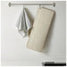 Beige bath mat with slats hanging on a towel rack against a white wall.