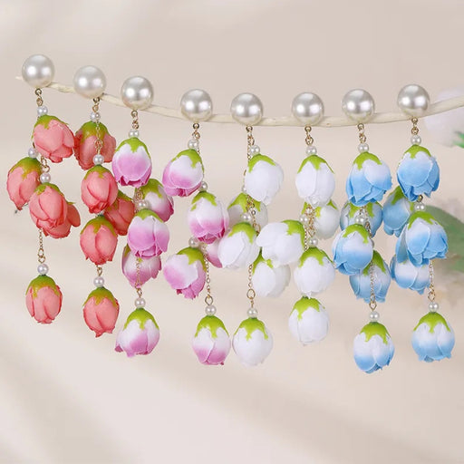 Digital Shoppy red bud earrings – floral drop earrings with red buds, white beads, and gold connectors on display surface


