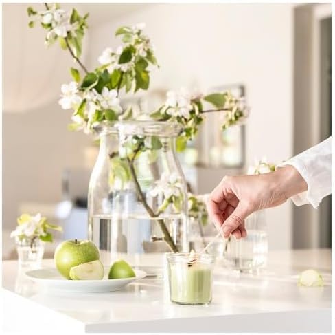 Bright kitchen scene with green apple dessert, glass pitcher, and floral arrangement – 50582053