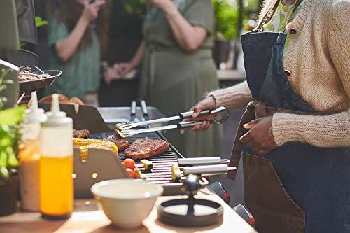 Person grilling food outdoors with a crowd in the background